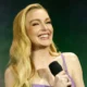 Lindsay Lohan surge radiante com vestido e bolsa Chanel