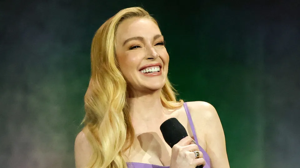 Lindsay Lohan surge radiante com vestido e bolsa Chanel